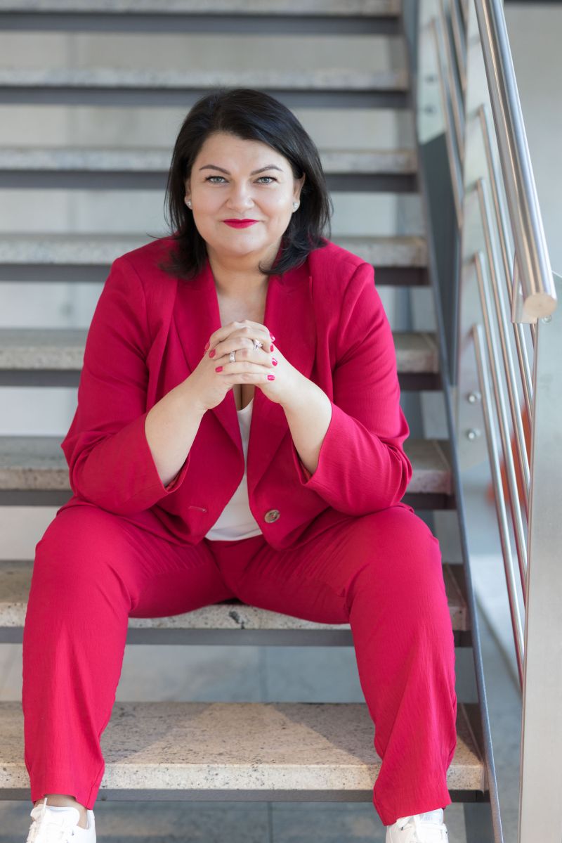 Ramona Meinzer im roten Anzug auf einer Treppe