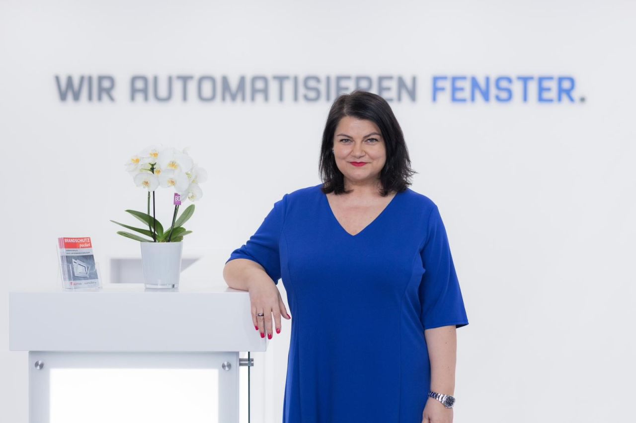 Ramona Meinzer vor dem Schriftzug Wir automatisieren Fenster